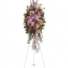 Tall floral spray on a stand with pink and purple flowers and ribbon