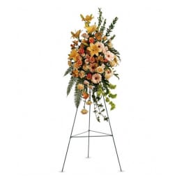 Tall floral standing spray on an easel with orange and peach flowers