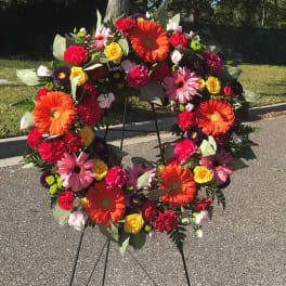 Colorful floral wreath on a black stand outdoors