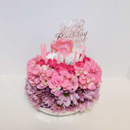Pink floral birthday cake with candles and a Happy Birthday topper