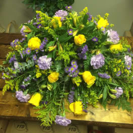 Large bouquet of yellow roses and lavender flowers on a wooden table