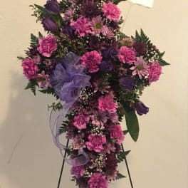 Purple and pink standing floral spray on an easel with a ribbon bow