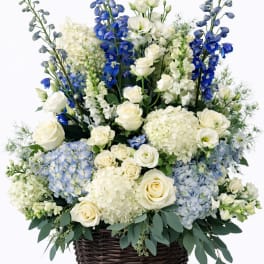 Blue and white floral arrangement in a wicker basket
