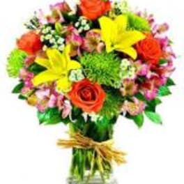 Bouquet of yellow lilies and orange roses in a glass vase