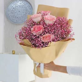 Pink rose bouquet wrapped in tan paper