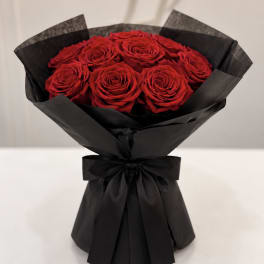 Bouquet of red roses wrapped in black paper with a black ribbon