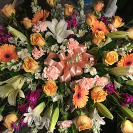 Large mixed bouquet with orange roses, lilies, gerbera daisies, and pink carnations