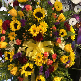Large bouquet with sunflowers, yellow roses, and mixed flowers tied with a yellow ribbon