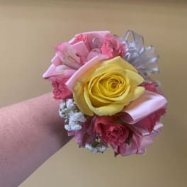 Pink and yellow rose wrist corsage with ribbon accents