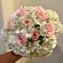 Pink roses and white flowers in a round bouquet