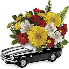Flower arrangement in a black toy car container