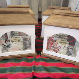 Decorative memorial lanterns with framed floral inserts and printed quotes
