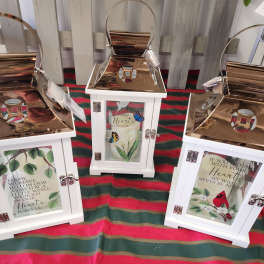 Three white lanterns with memorial messages and butterfly designs