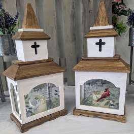 Two wooden memorial lanterns with cross cutouts and printed bird designs