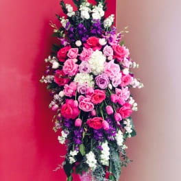 Tall standing floral spray with pink, purple, and white flowers