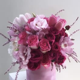 Pink and white bouquet of roses and tulips in a pink box