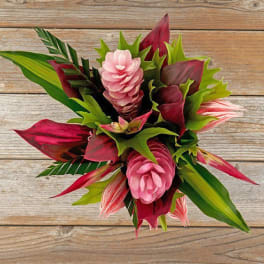 Tropical bouquet with pink cone-shaped blooms and bold red and green foliage viewed from above