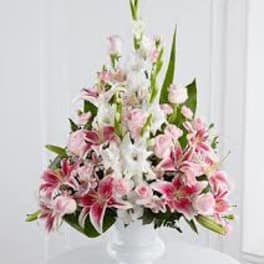 Pink and white lily arrangement in a clear vase