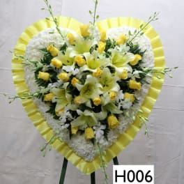 Heart-shaped floral standing spray with yellow roses and white lilies