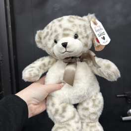 Plush teddy bear with a ribbon bow and hanging tag