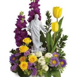 Floral arrangement with a white statue centerpiece, yellow tulips, and purple flowers