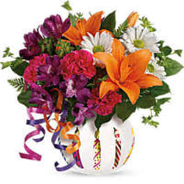 Colorful bouquet with lilies, daisies, and carnations in a white vase