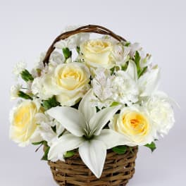 White and pale yellow flowers arranged in a wicker basket