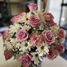 Bouquet of pink roses and white daisies with a pink carnation