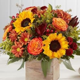 Autumn bouquet with sunflowers, roses, and daisies in a wooden box