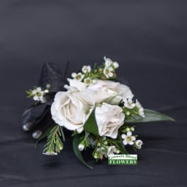 White rose boutonniere with small white blossoms and black ribbon