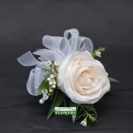 White rose corsage with pale ribbon and small white accents