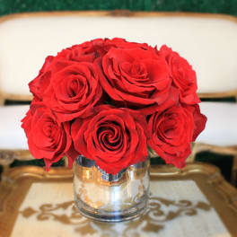 Red roses arranged in a clear glass vase