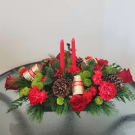 Red floral centerpiece with candles, pinecones, and ribbon accents