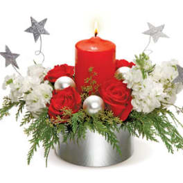 Red candle with red and white flowers in a silver container