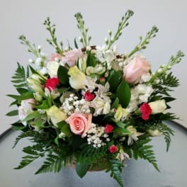Mixed bouquet of pink and white flowers in a basket