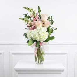 Bouquet of pale pink roses and white hydrangeas in a clear glass vase