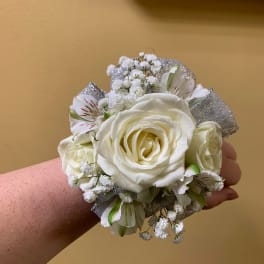 White rose wrist corsage with small white filler flowers and silver ribbon