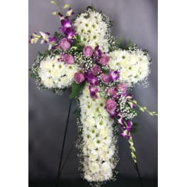 White and purple floral cross on a stand