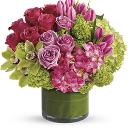 Pink roses and tulips in a green glass vase