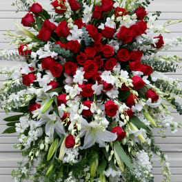 Large standing floral spray with red roses, white lilies, and white orchids