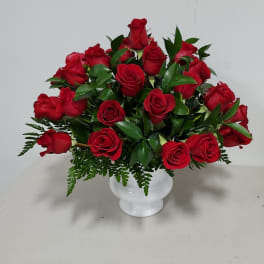 Red roses arranged in a white vase