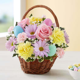 Pastel flower basket with roses, daisies, carnations, and Easter eggs