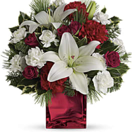Red and white floral arrangement in a red glass vase