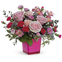 Pink and red mixed flower arrangement in a magenta vase