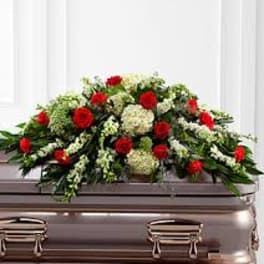 Red and white floral casket spray on a silver casket