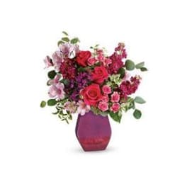 Bouquet of pink and red flowers in a purple vase