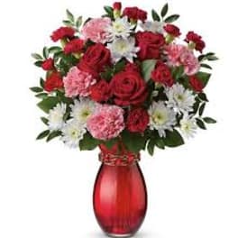 Red and pink mixed bouquet in a red glass vase