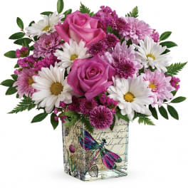 Pink roses and white daisies in a square glass vase with butterfly artwork