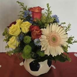 Mixed bouquet in a soccer ball vase with roses and a gerbera daisy