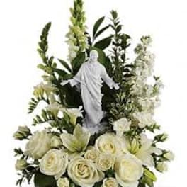 White floral arrangement with a religious statue centerpiece